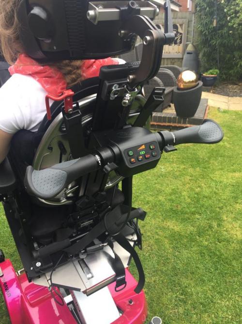This is a photo of a Scoot Control mounted on the back of a wheelchair